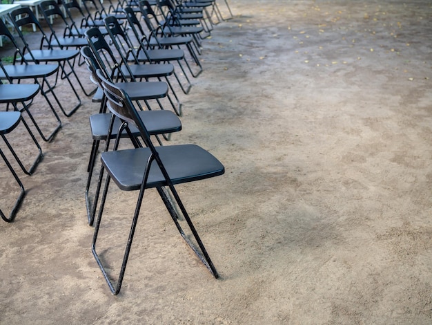 Rows of black metal folding chairs on the ground