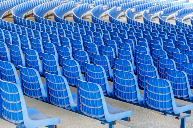 Ряды синих пластиковых стульев на металлическом основании рядами по кругу в зале для бизнес-презентаций