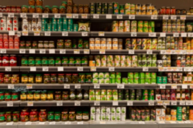 Photo rows of cans of canned food on the shelves in the store. front view. blurred.