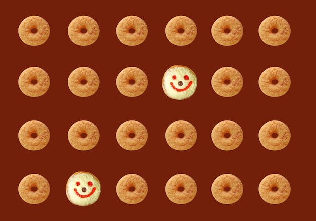 Rows of Cinnamon Doughnuts with Smiling Face Coconut Flakes Jelly Donuts Pattern on Brown Background