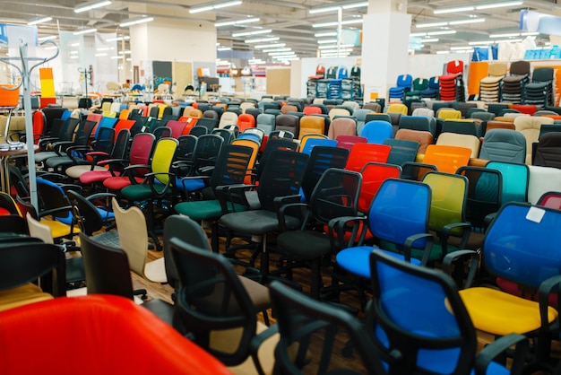 Rows of different office chairs in furniture store showroom, nobody. Comfort seats samples in shop, goods for modern interior