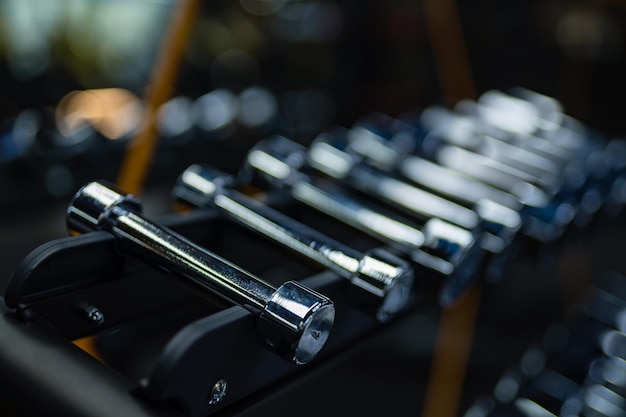 Rows of dumbbells in the gym with hign contrast and monochrome color tone