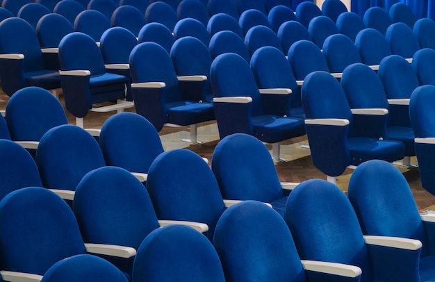 The rows of empty blue seats in the movie theater or conference hall