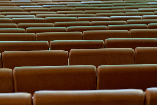 Rows of empty brown seats in the auditorium