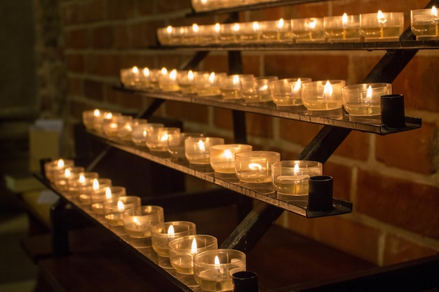 暗闇の中で輝くキャンドルの列 燃える炎を持つキャンドル 教会の装飾