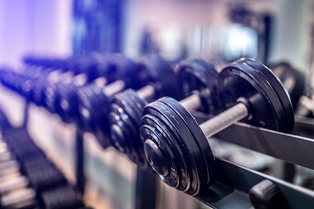 Rows of heavy iron dumbbells in the gym Workout training and fitness gym concept Sport equipment and tool theme