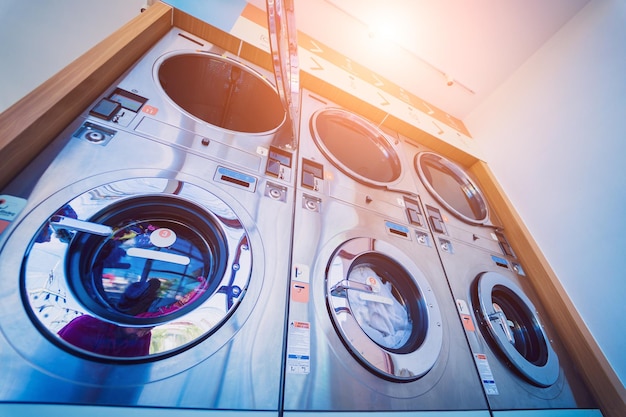 Foto righe di lavatrici industriali nella grande lavanderia a gettoni