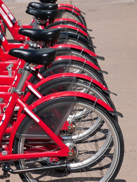 Rows of red bikes that are used for rentals to to get around Denver are both useful for fun and exercise but also good for the environment as it saves on car usage and gas and traffic and exhaust.