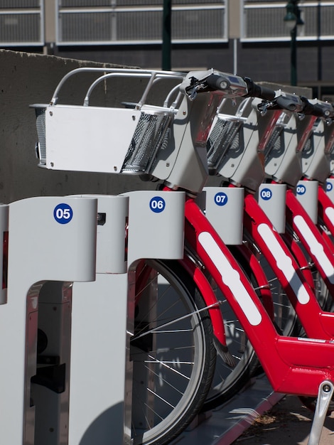 Le file di biciclette rosse che vengono utilizzate per il noleggio per spostarsi a denver sono sia utili per il divertimento che per l'esercizio fisico, ma anche utili per l'ambiente in quanto risparmiano sull'uso dell'auto e sul gas, sul traffico e sui gas di scarico.