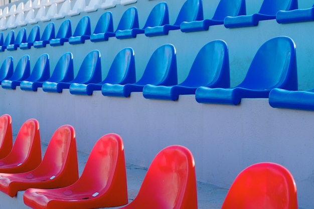 Foto file di sedili rossi, blu e bianchi per gli spettatori nelle tribune dello stadio