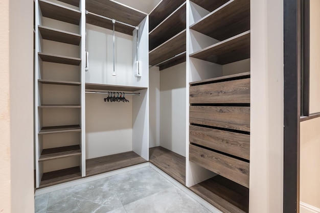 Rows of shelves and clothes hangers in the wardrobe empty big wardrobe room in modern apartment or hotel