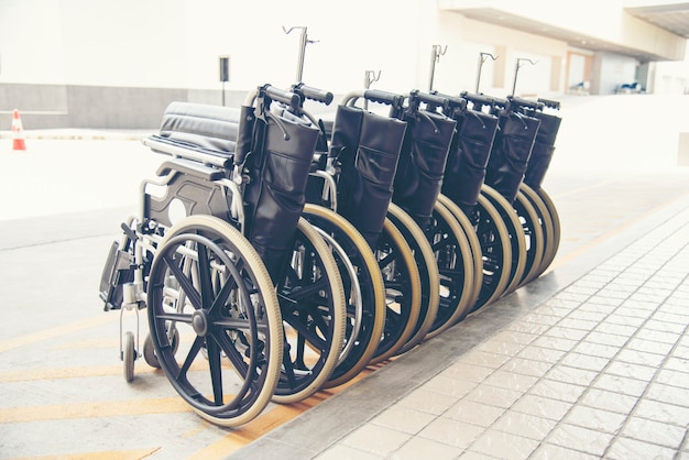 Rows of wheelchairs parking for disability patient services in medical hospital with copy space.
