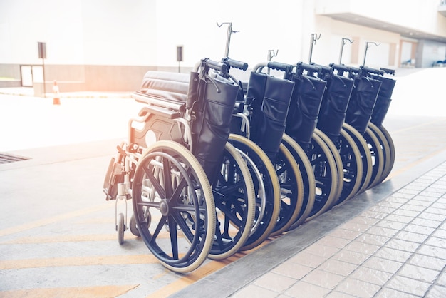 Rows of wheelchairs parking for disability patient services in medical hospital with copy space.
