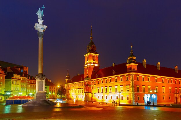 Royal Castle en Sigismund Column op Castle Square verlicht in de oude stad van Warschau op regenachtige nacht, Polen.