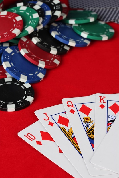 Royal flush with poker chips on a red poker table closeup