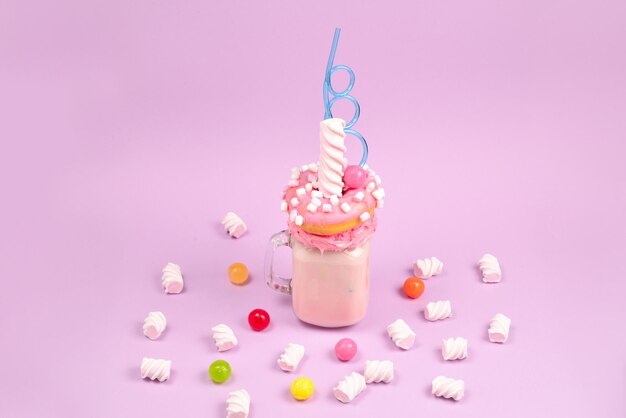 Roze aardbeienfreakshake met marshmallow en snoep.