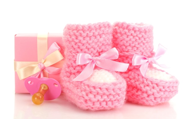 Roze baby laarzen, fopspeen en cadeau geïsoleerd op wit