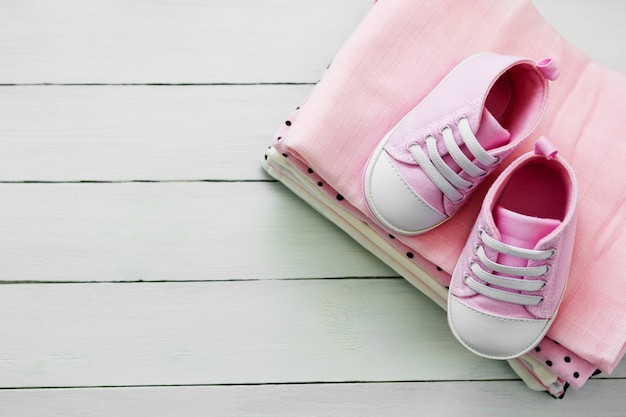 Roze baby meisje schoenen en pasgeboren kleding. Moederschap, onderwijs of zwangerschap concept met kopie ruimte. plat lag.