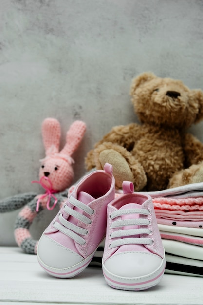 Roze baby meisje schoenen, pasgeboren kleding en zacht speelgoed. Moederschap, onderwijs of zwangerschap concept met kopie ruimte.