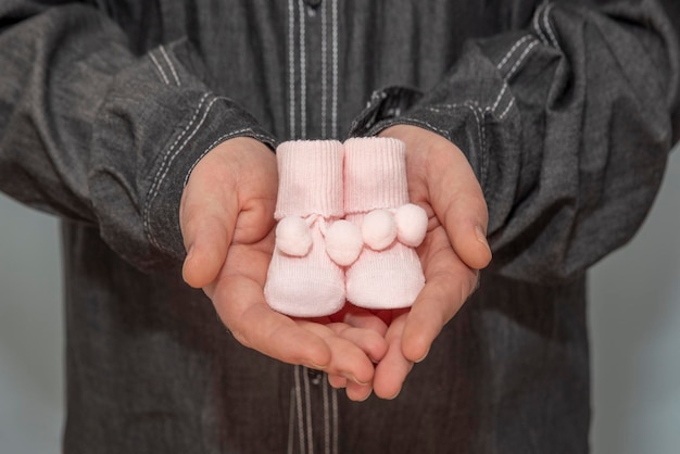 Roze babyslofjes in vaders hand