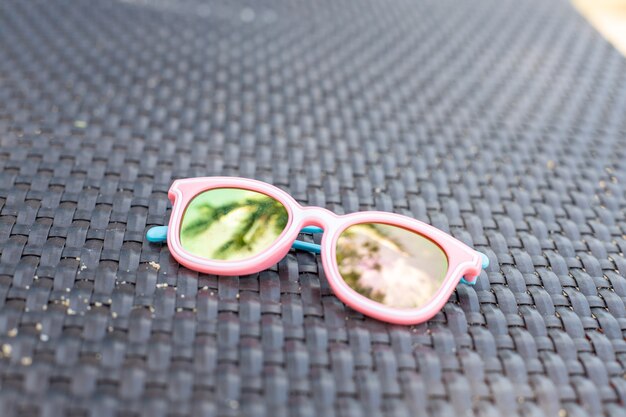 roze babyzonnebril met palmboomreflectie. Hoge kwaliteit foto