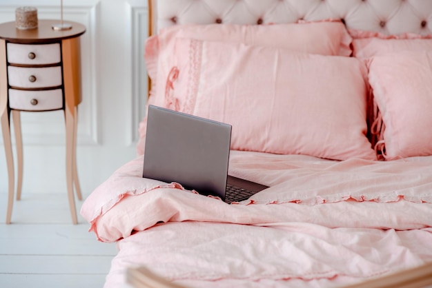 Roze bed met prachtig verfrommeld linnengoed in een witte slaapkamer Werk op afstand vanuit huis