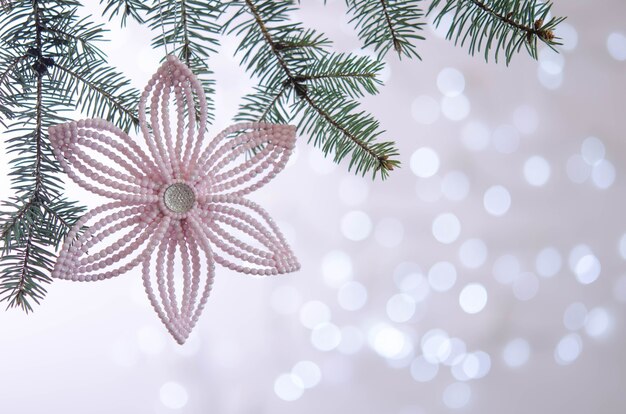 Foto roze bloem hangt aan een kerstboomtak