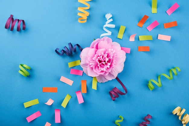 Roze bloem met gekleurd papier op de blauwe achtergrond