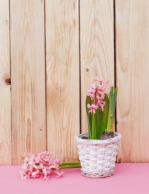 Roze bloemen in een vaas op een houten achtergrond. roze achtergrond