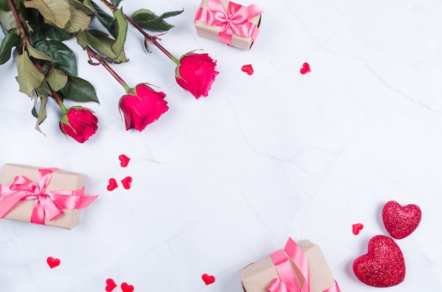 Roze bloemen met cadeautjes op tafel van bovenaf met kopie ruimte, plat leggen.