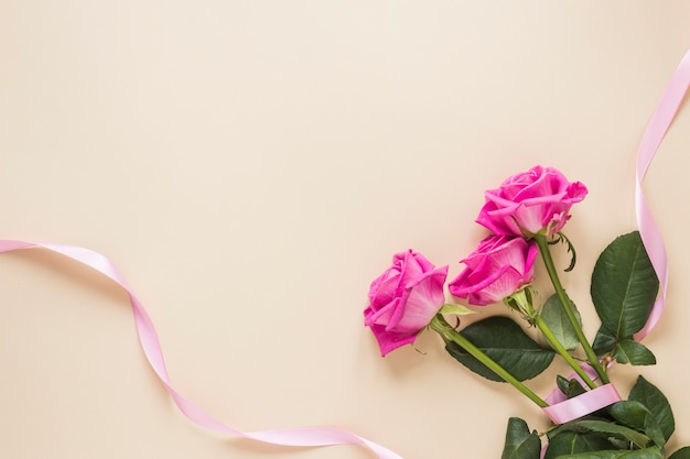 Foto roze bloemen met lint op tafel