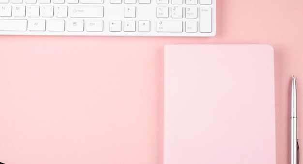 Roze bureau met toetsenbord en notebook. bovenaanzicht met kopieerruimte