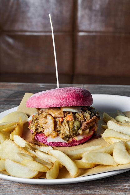 Foto roze burger met italiaanse cassuola op een tafel in een restaurant een traditioneel gerecht op een moderne manier met frietjes