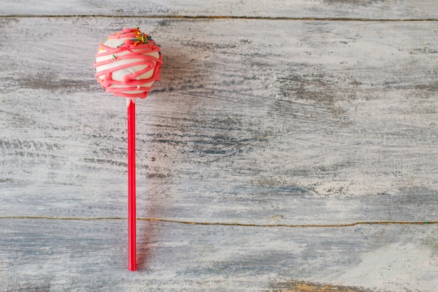 Roze cakepop. suikerglazuur en hagelslag. dessert met frambozensmaak. biscuitgebak en witte chocolade.