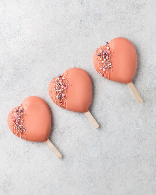 Roze cakepops ijslollys Roze harten Liefde en zoet concept Valentijnsdag Witte achtergrond