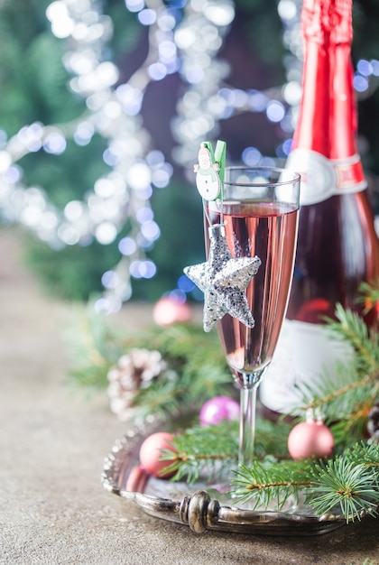 Roze champagne in een glas en kerstversiering