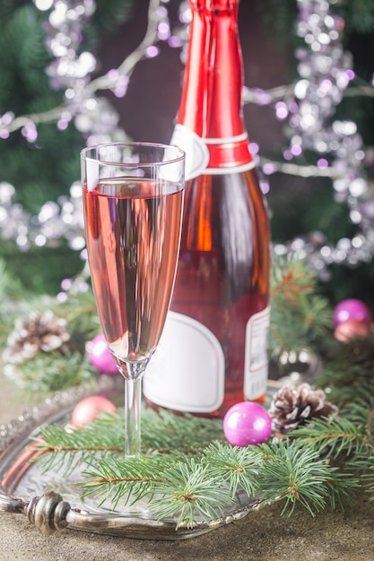 Roze champagne in een glas en kerstversiering