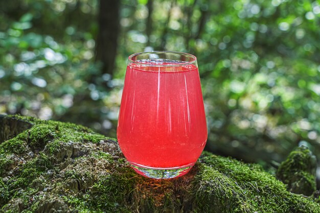 Roze cocktaildrank op hout met mos