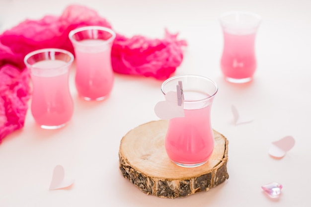 Roze cocktails in glazen en papieren hartjes op een roze achtergrond Drinks for lovers