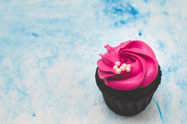 Roze cupcake op een blauwe achtergrond