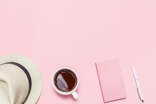 Roze dagboek, witte pen en bloeiende takje op roze bureau. Minimalistische plat lag samenstelling