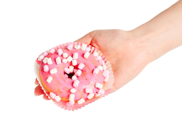 Roze donut met marshmallow in vrouw hand geïsoleerd op wit