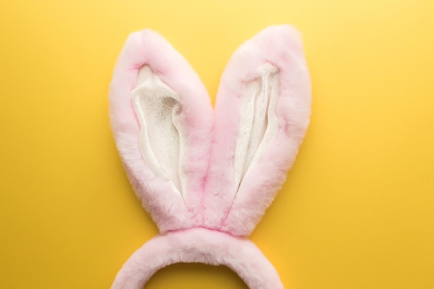 Roze easter bunny oren op de gele achtergrond hoge kwaliteit foto