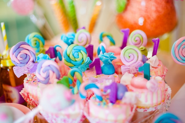 Roze en blauwe cupcakes met gekleurde lollypops voor candybar