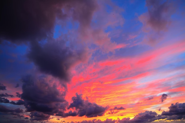 Roze en blauwe lucht met donkere wolken bij zonsondergang