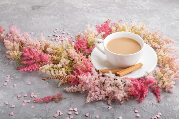 Roze en rode astilbe bloemen en een kopje koffie