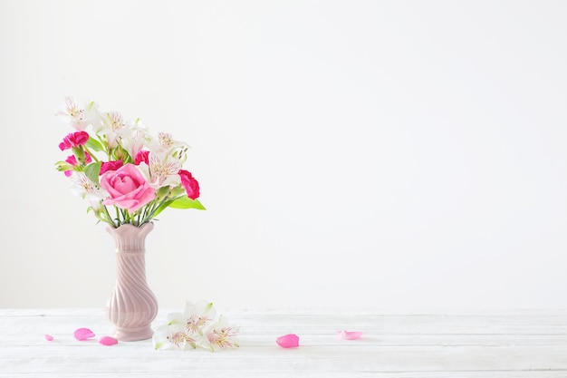 Roze en witte bloemen in vaas op witte achtergrond