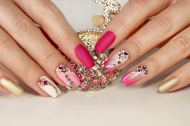 Roze en witte manicure met strass-steentjes