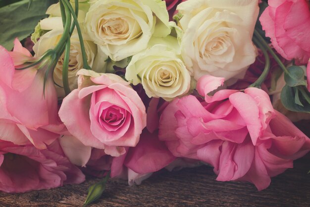 Roze en witte verse rozen en eustoma bloemen close-up, retro afgezwakt