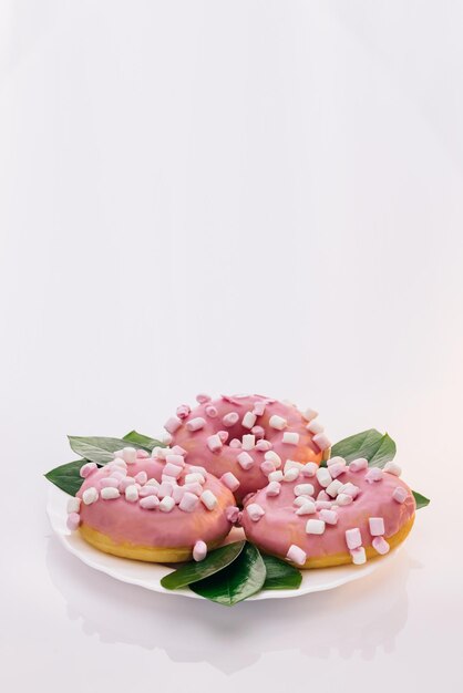 Roze geglazuurd en hagelslag donuts wit smakelijke heerlijke zoete donut met kleurrijke hagelslag op wit